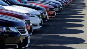 Various color cars lined up on a car lot.