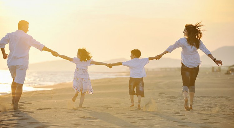 Family running together on the beach.