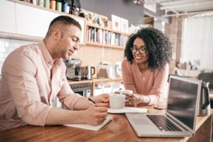 man and woman leaning on a counter discussing a budget