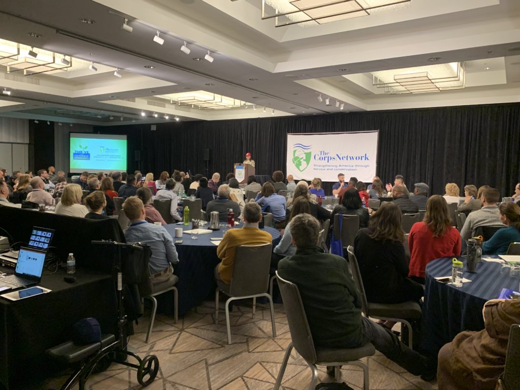 people sitting in a ballroom listening to a speech