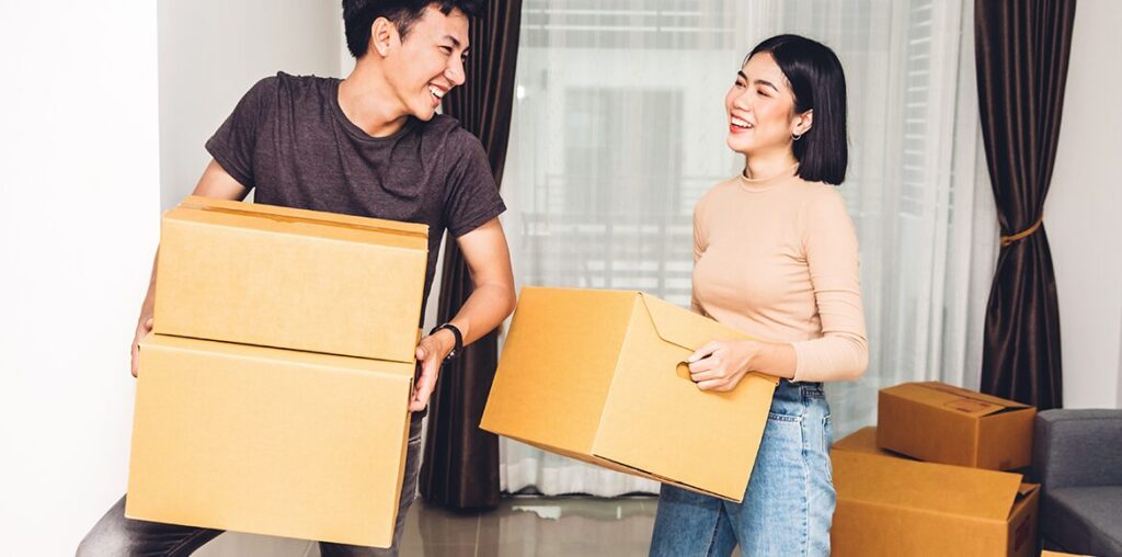 a young asian couple with moving boxes