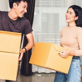 a young asian couple with moving boxes
